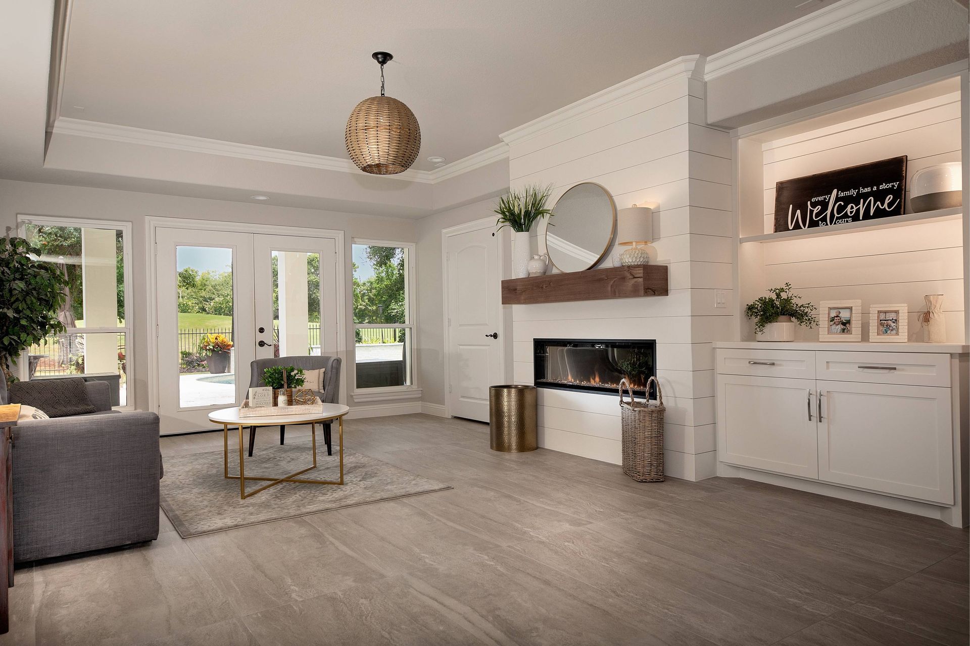 A living room with a fireplace , couch , table and cabinets.