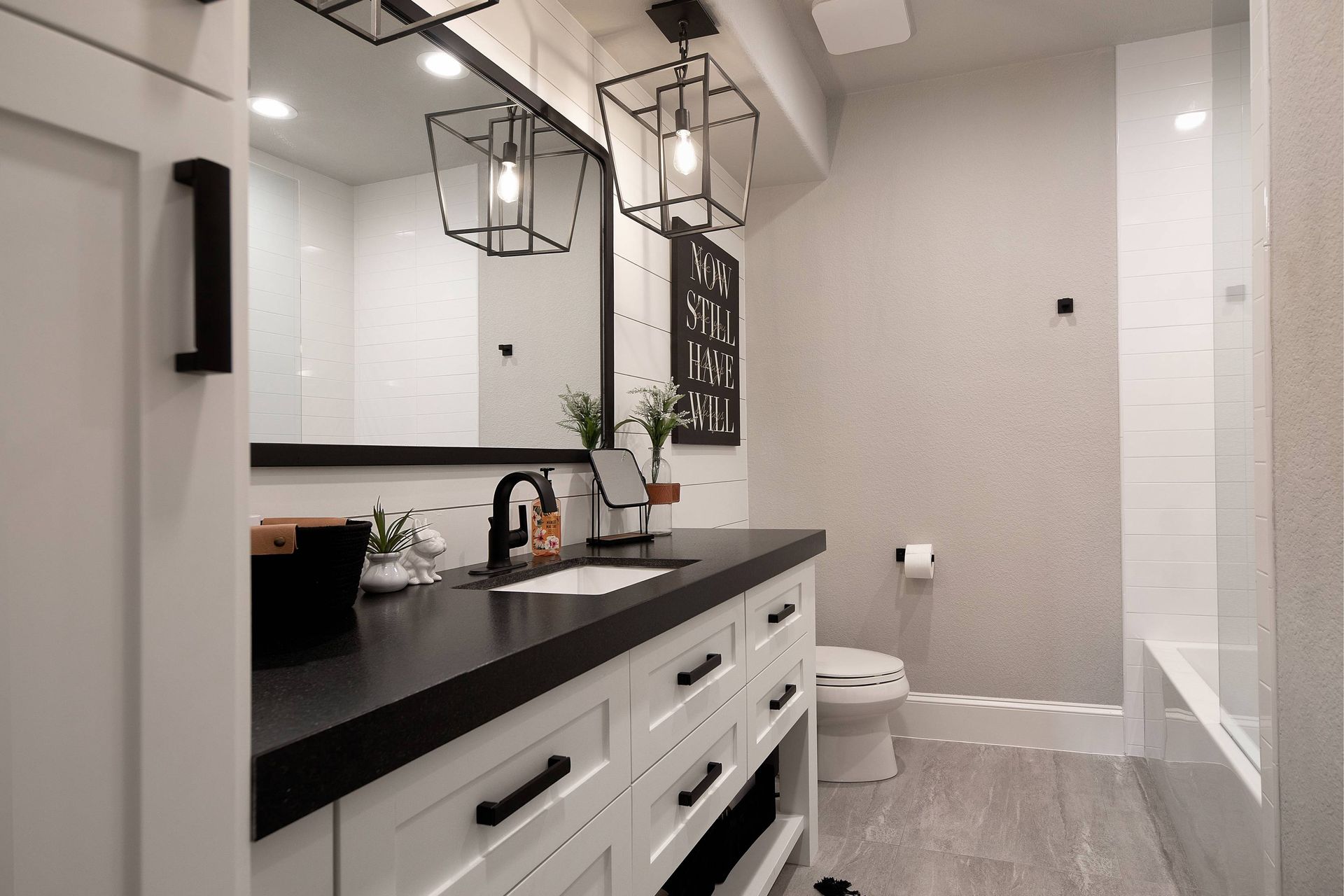 A bathroom with a sink , mirror , toilet and bathtub.