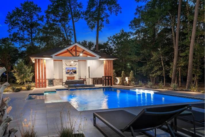 There is a large swimming pool in the backyard of a house.