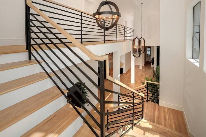 The stairs are made of wood and metal and have a black railing.