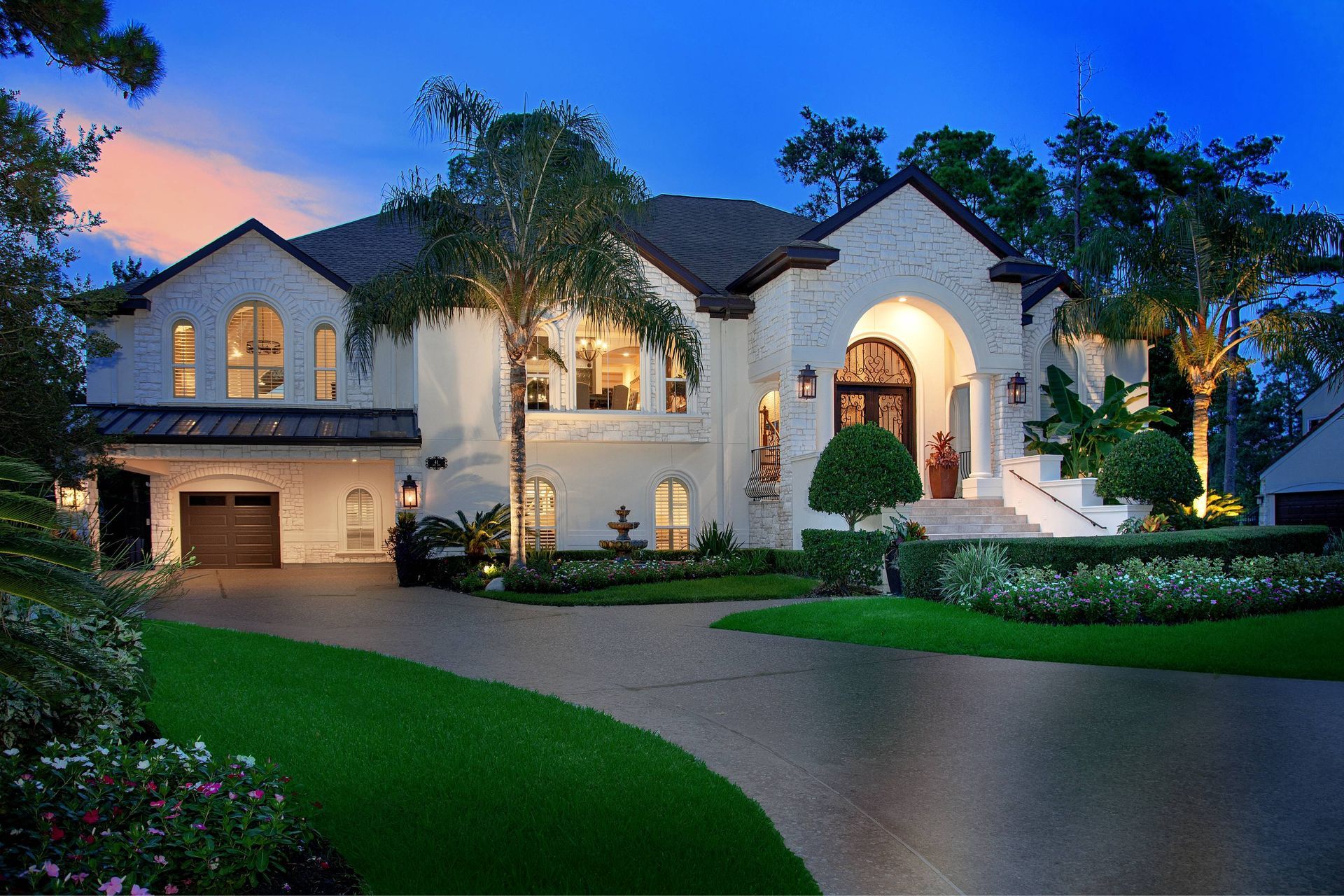 A large white house with a lot of windows is lit up at night