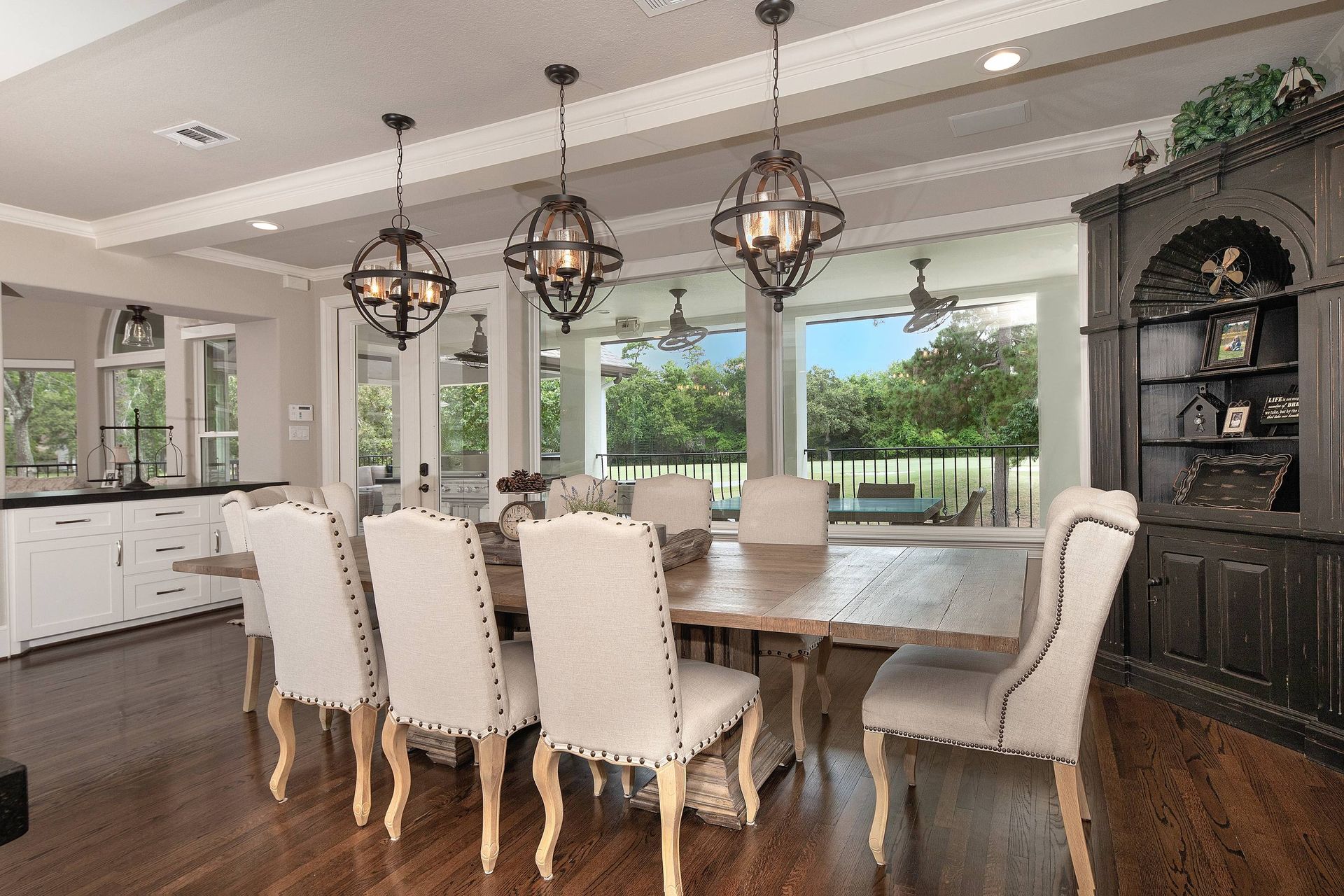 A dining room with a table and chairs and a ceiling fan.