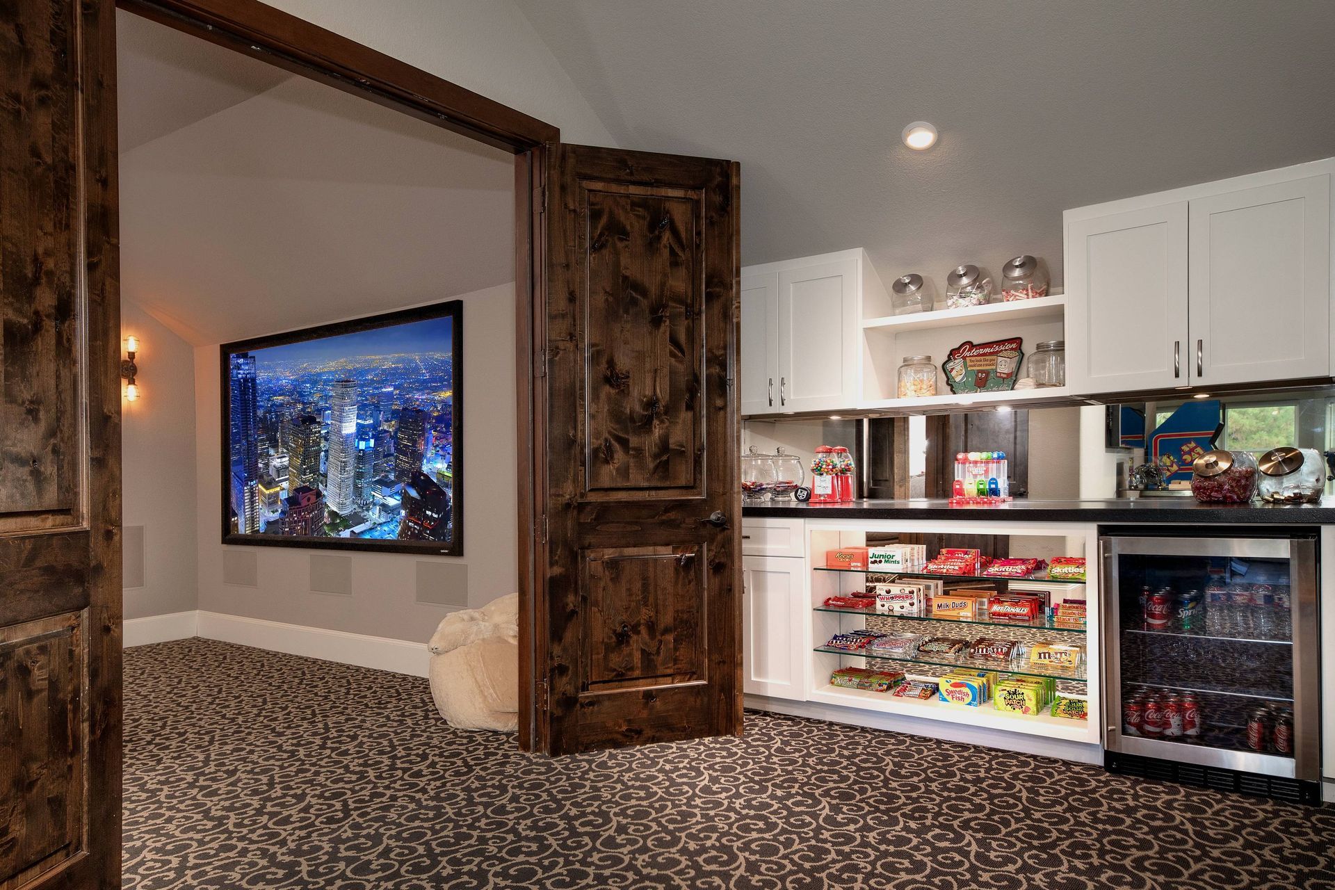 A home theater with a flat screen tv and a snack bar.