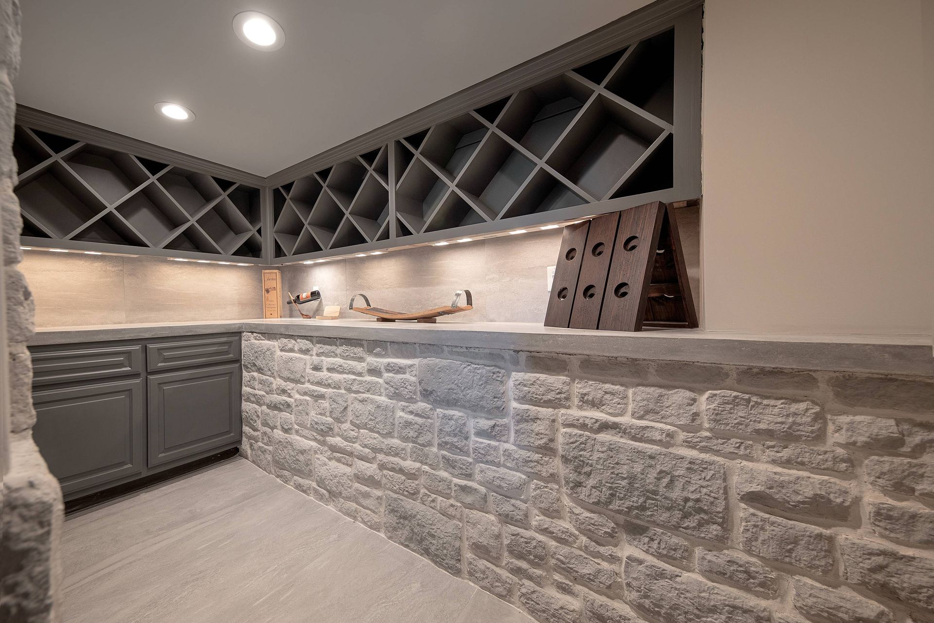 A kitchen with a stone wall and a wine rack.