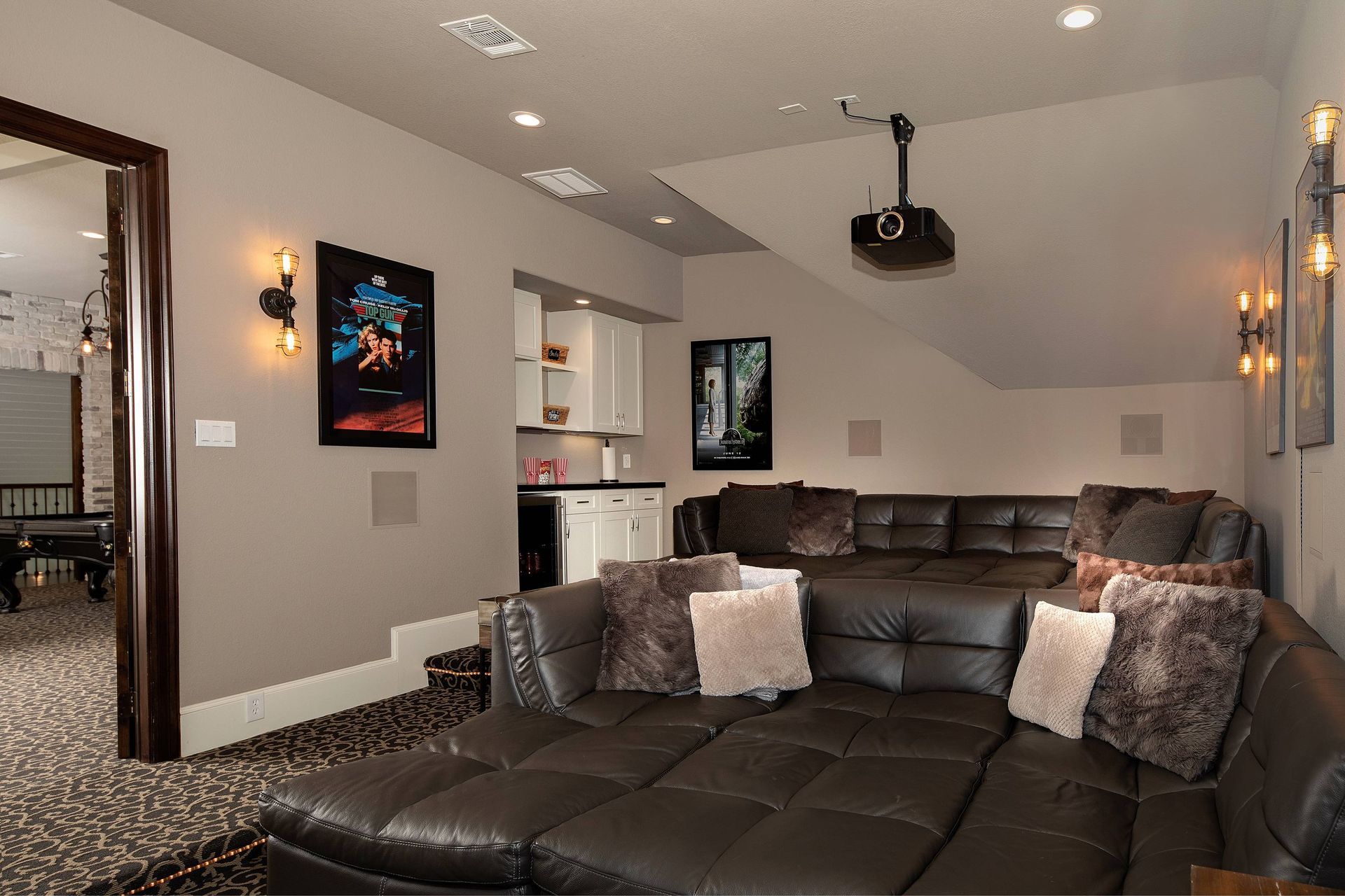 A living room with a large sectional couch and a projector