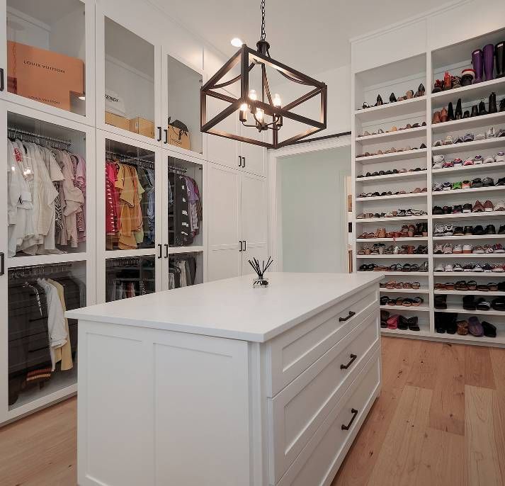 A walk in closet with a large island in the middle