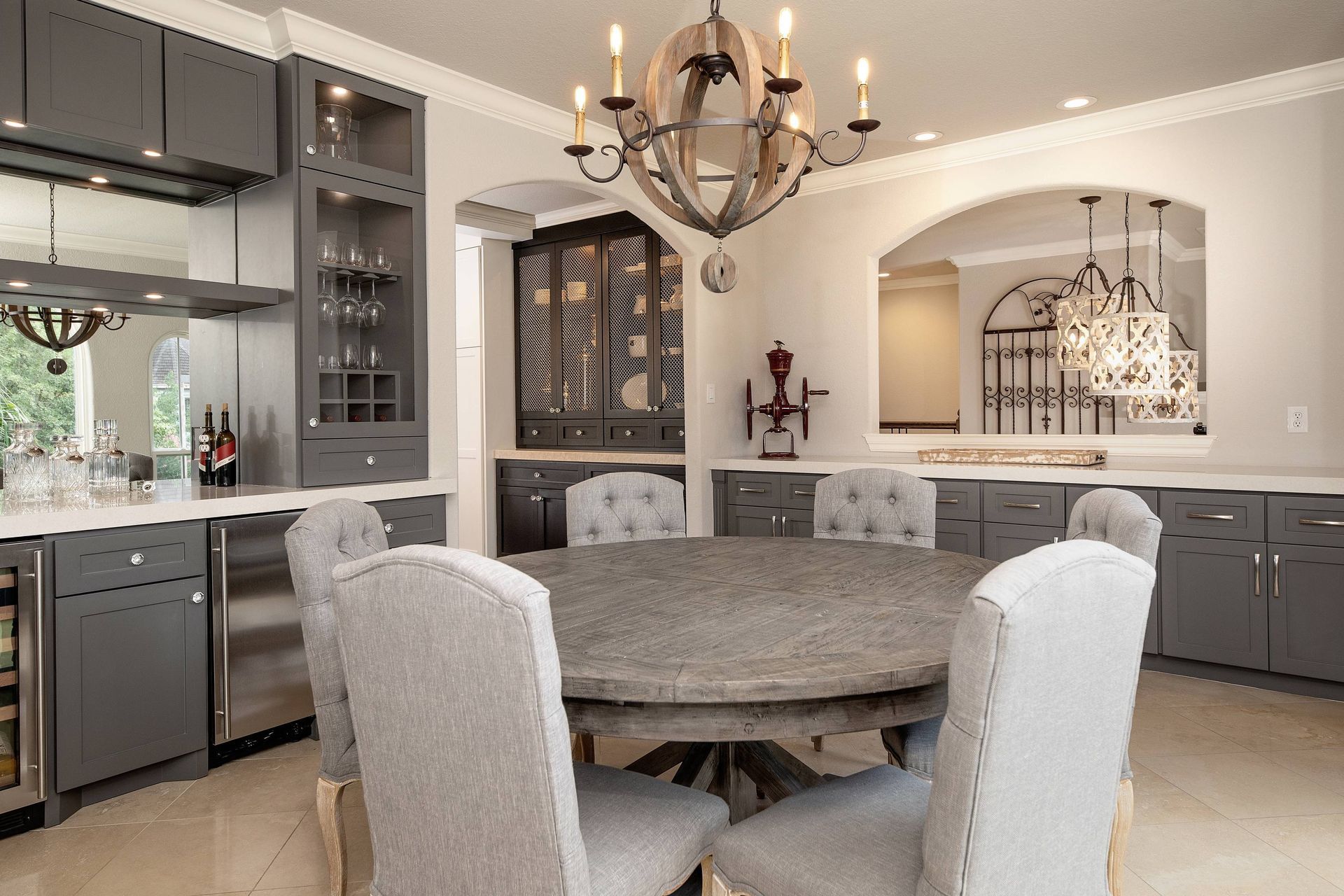 A dining room with a round table and chairs and a chandelier.
