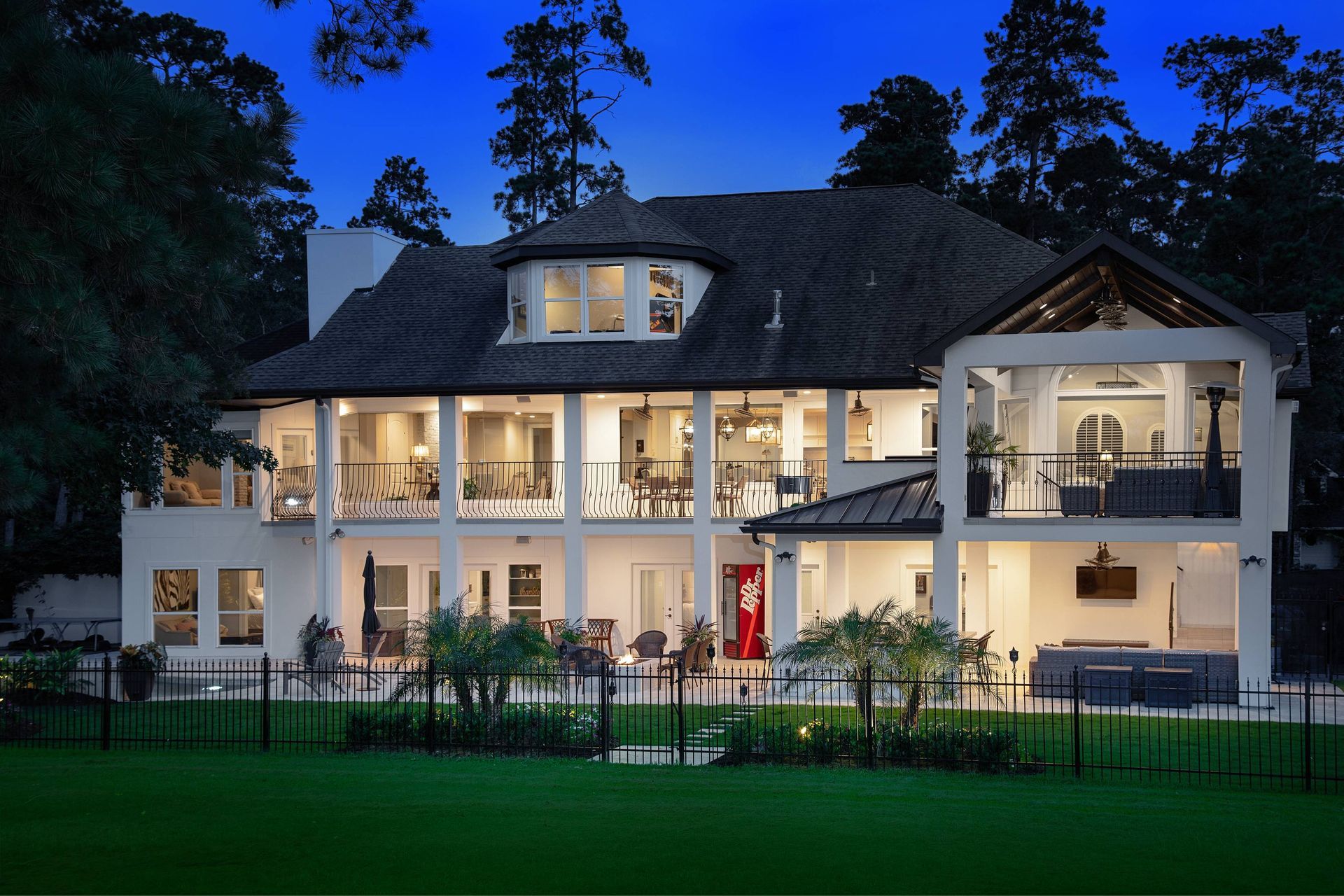A large house with a lot of windows is lit up at night