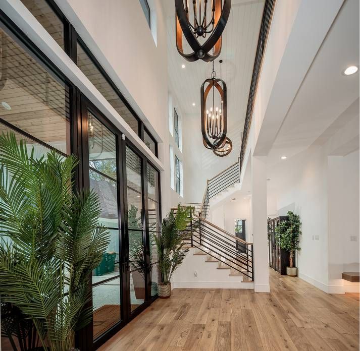A hallway with a staircase and lots of windows