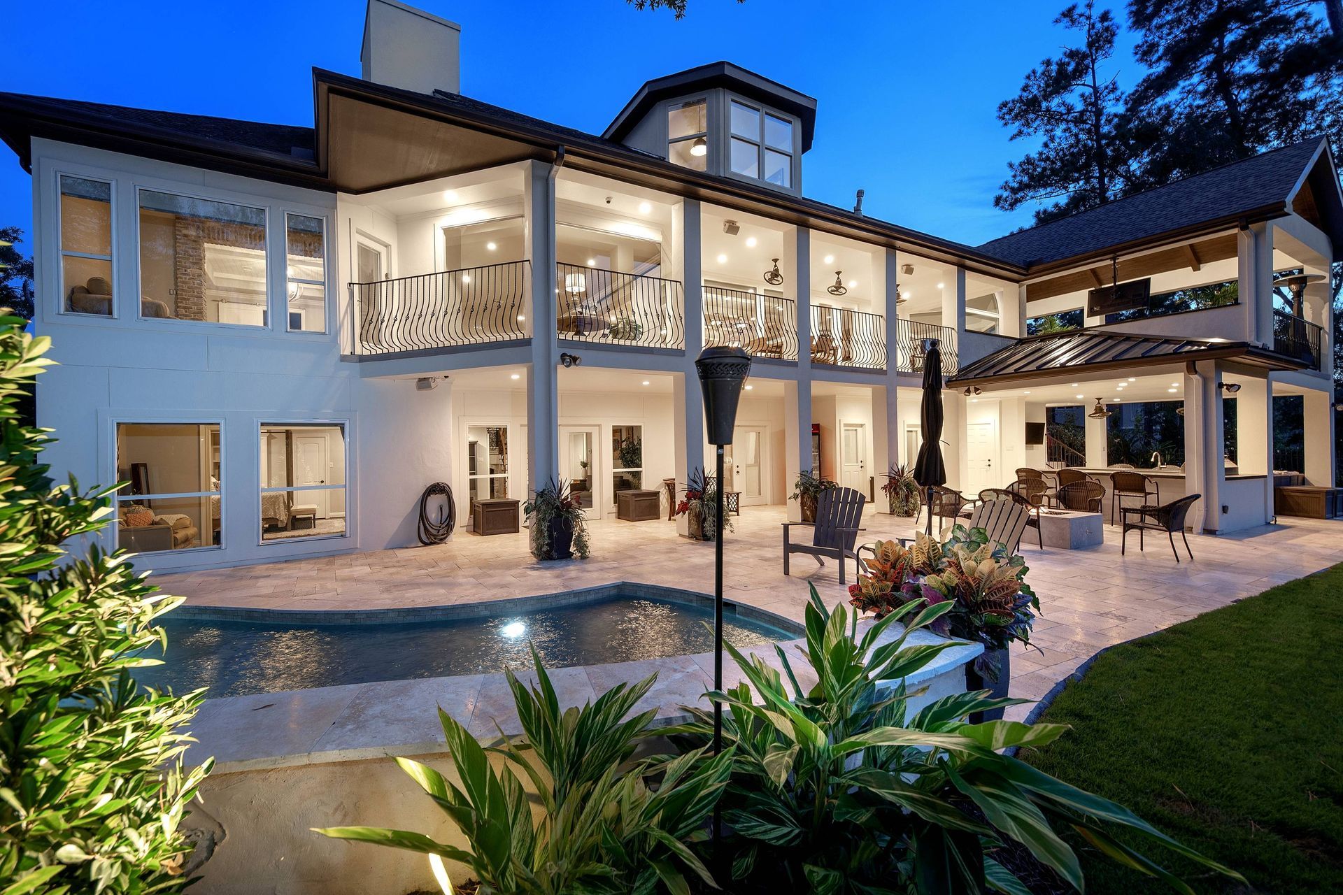 A large white house with a swimming pool in front of it