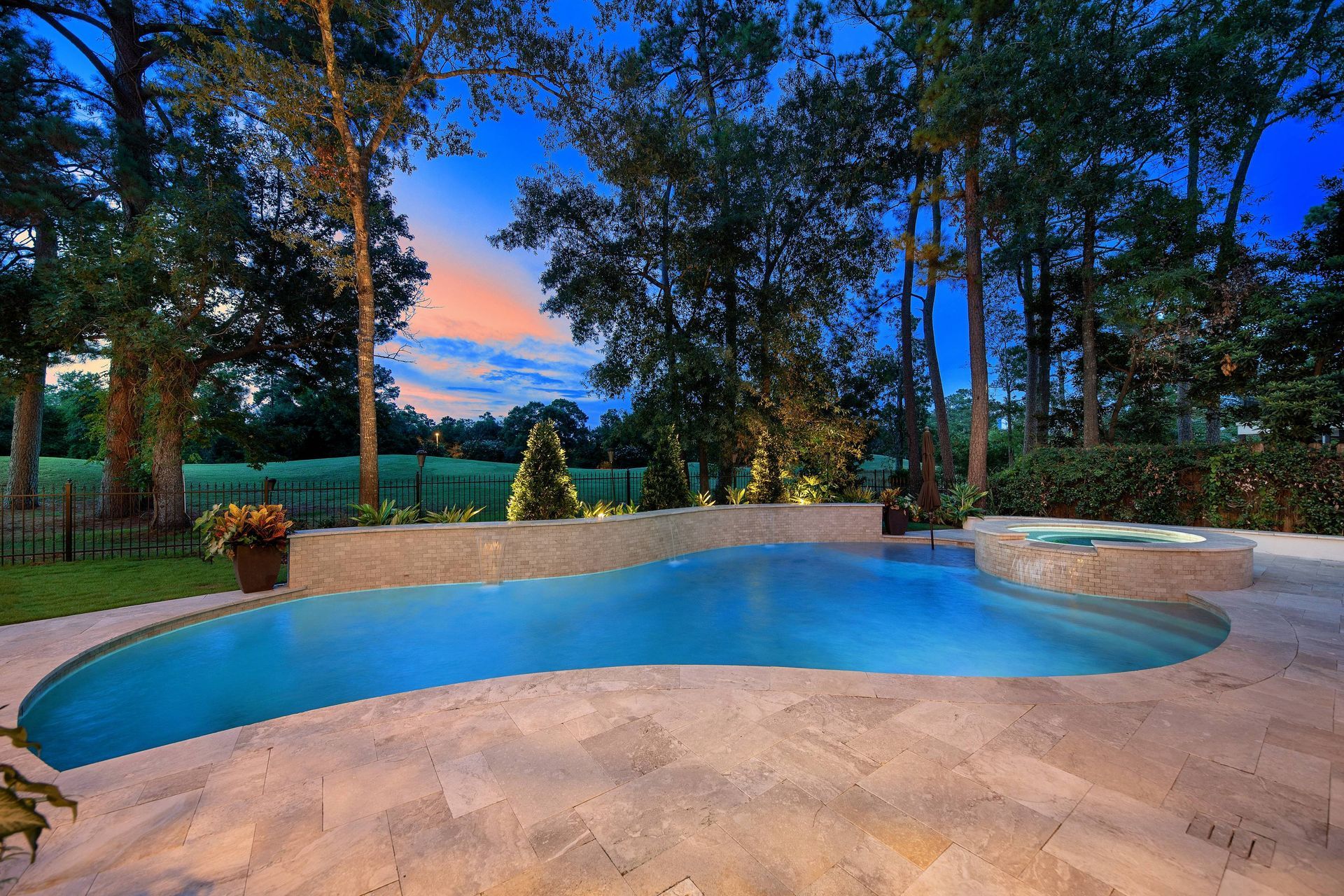 A large swimming pool in a backyard with trees in the background