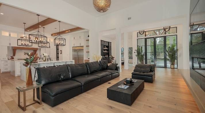 A living room with a large black couch and a coffee table.