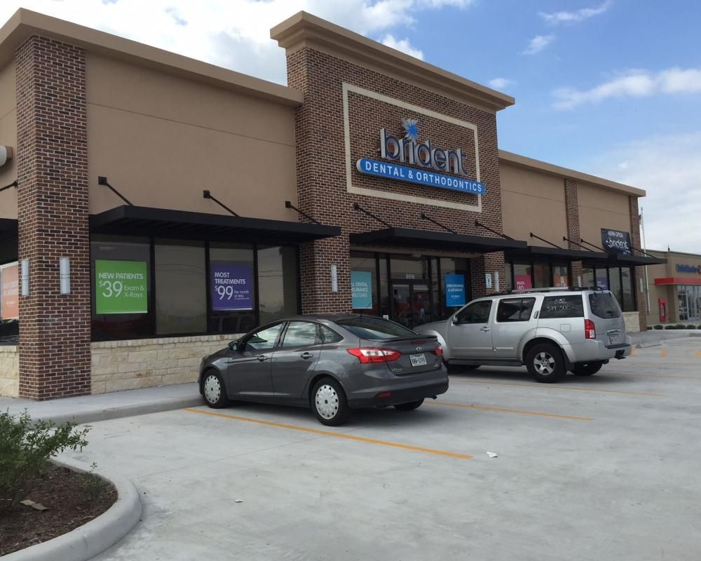 A dental office with cars parked in front of it