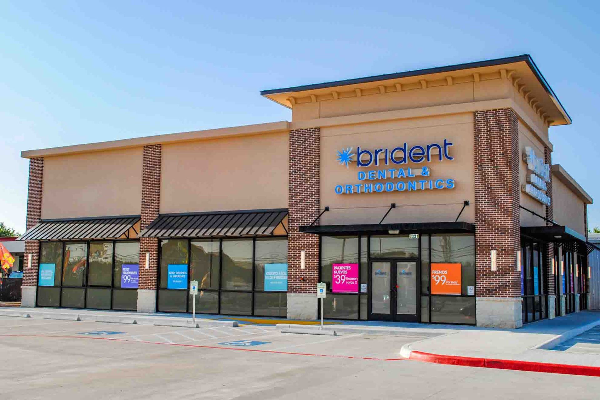A dental office with a lot of windows and a blue sign on the side of the building.