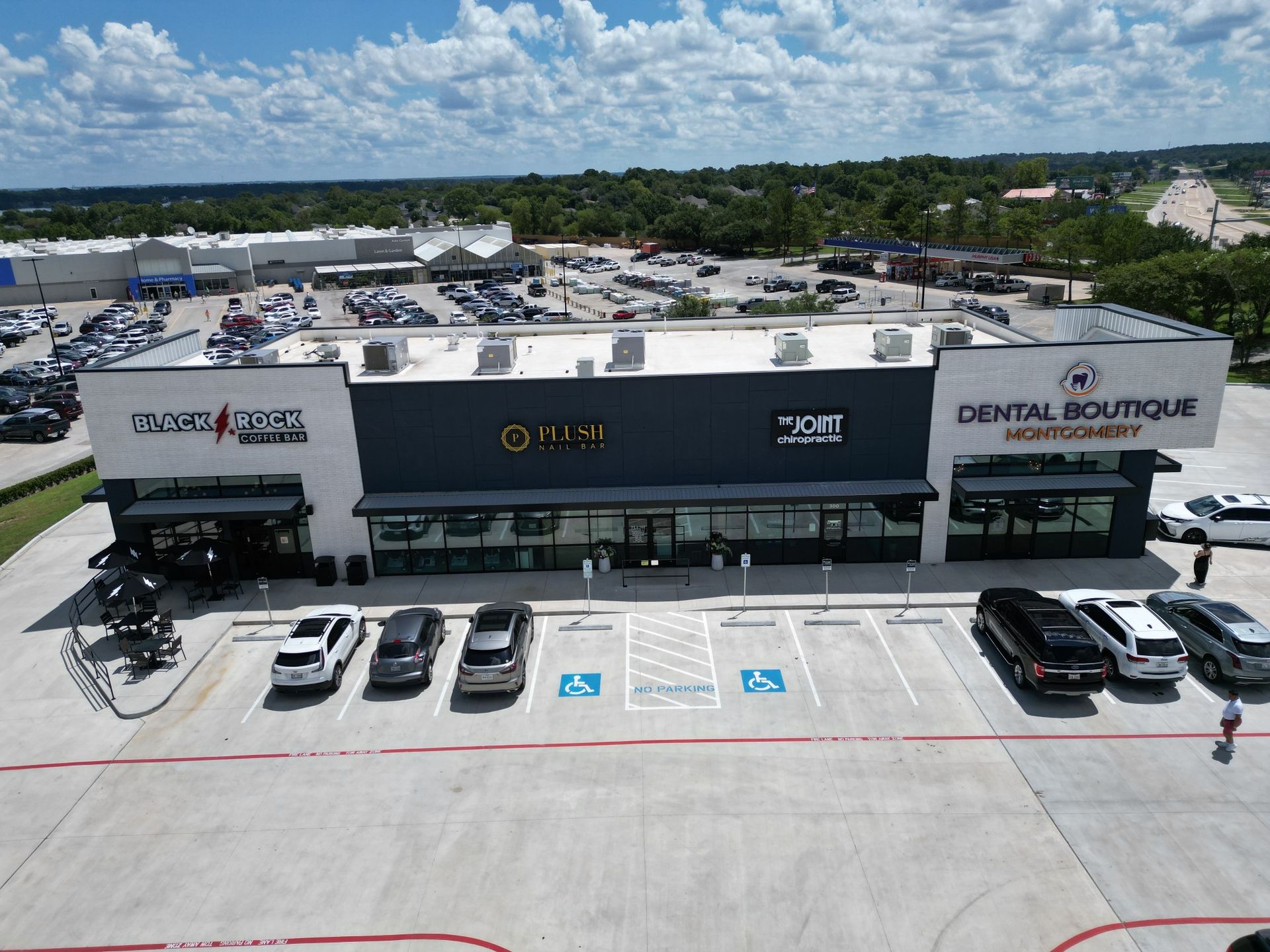 An aerial view of a dental boutique with cars parked in front of it.