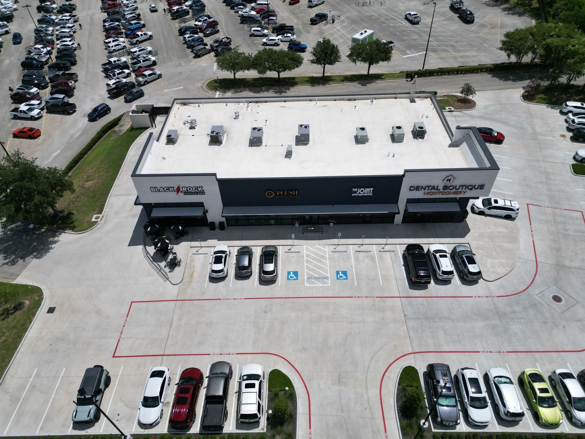 An aerial view of a car dealership with cars parked in front of it