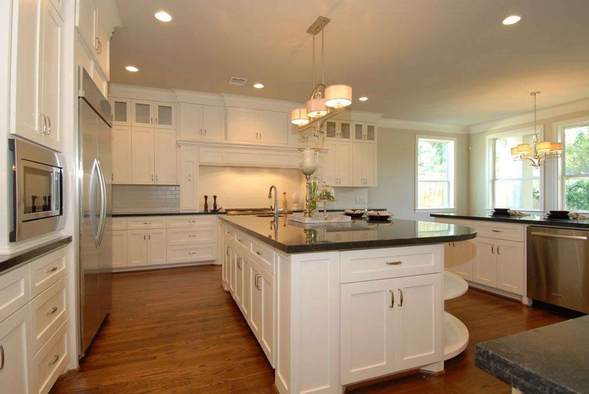 A large kitchen with white cabinets and stainless steel appliances