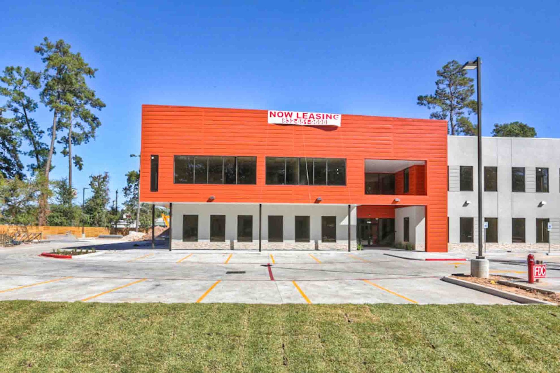 A large building with a lot of windows and a parking lot in front of it.