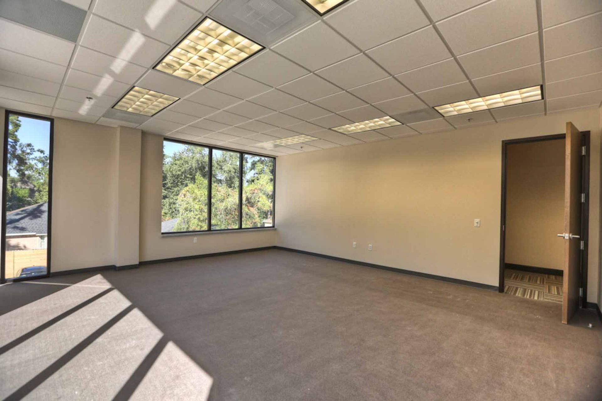 An empty room with a lot of windows and a door