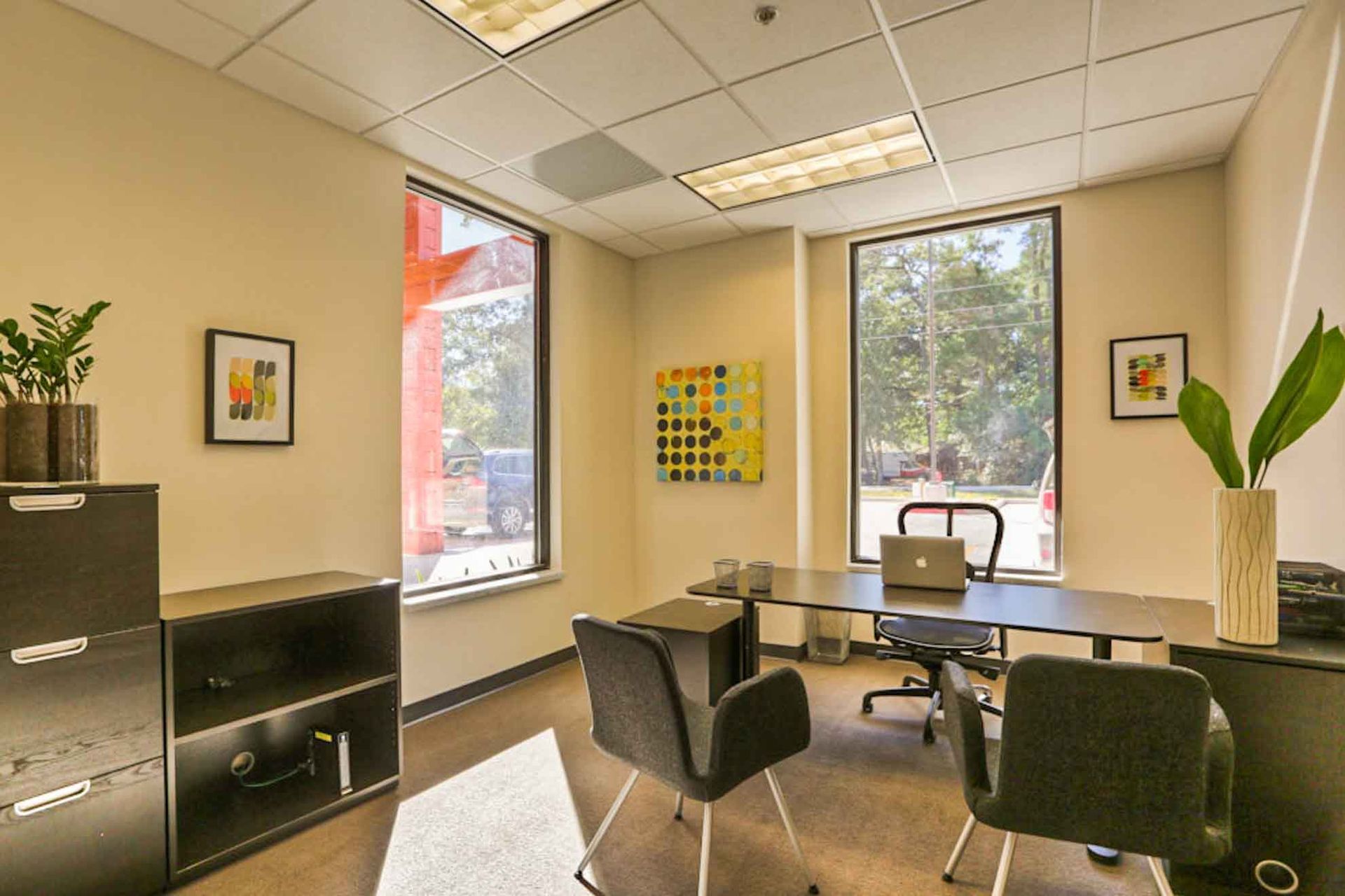 A small office with a desk and chairs in it