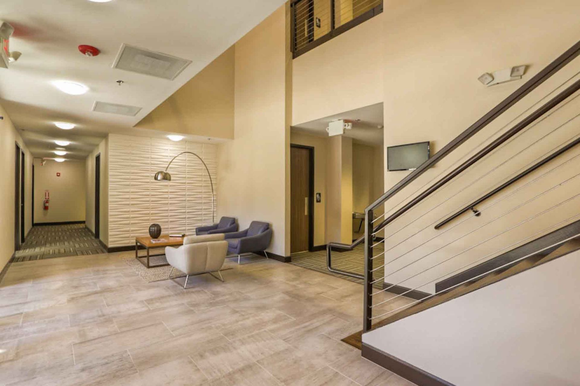 A lobby with stairs leading up to the second floor of a building.