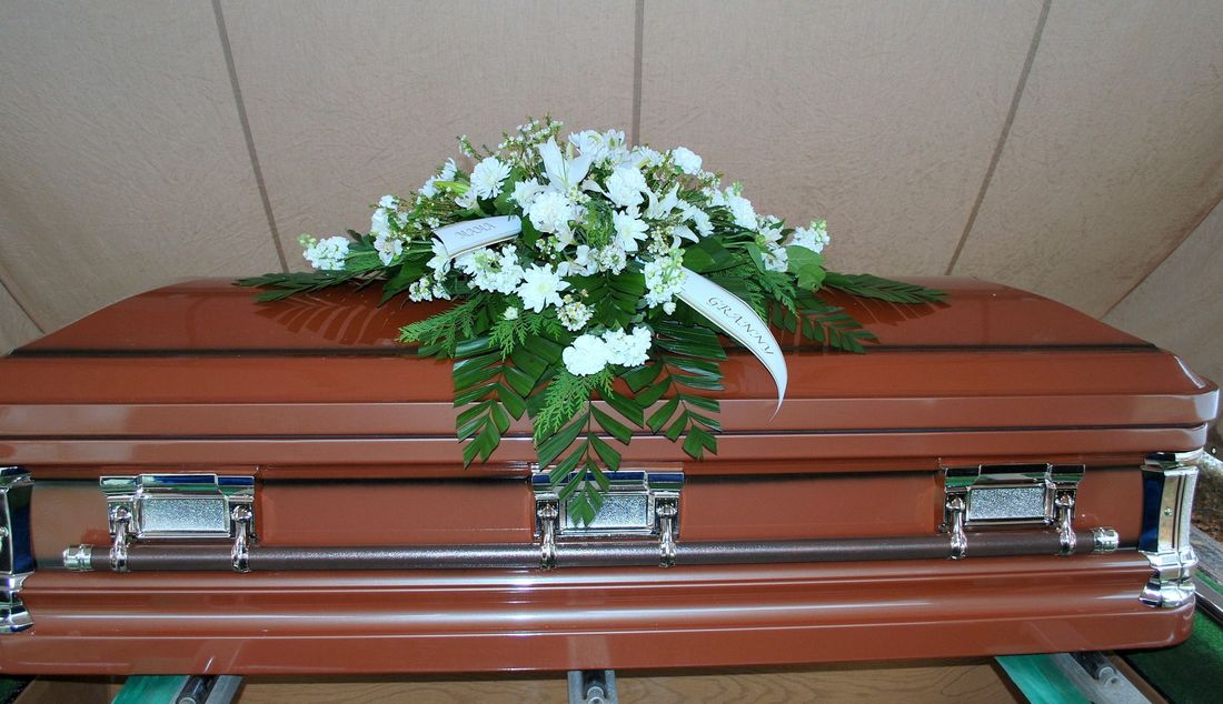 cuscino di fiori su cofano funebre