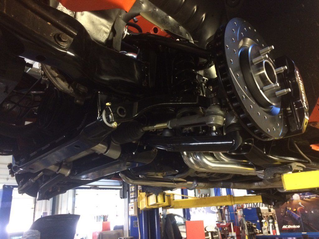 A car is sitting on a lift in a garage.