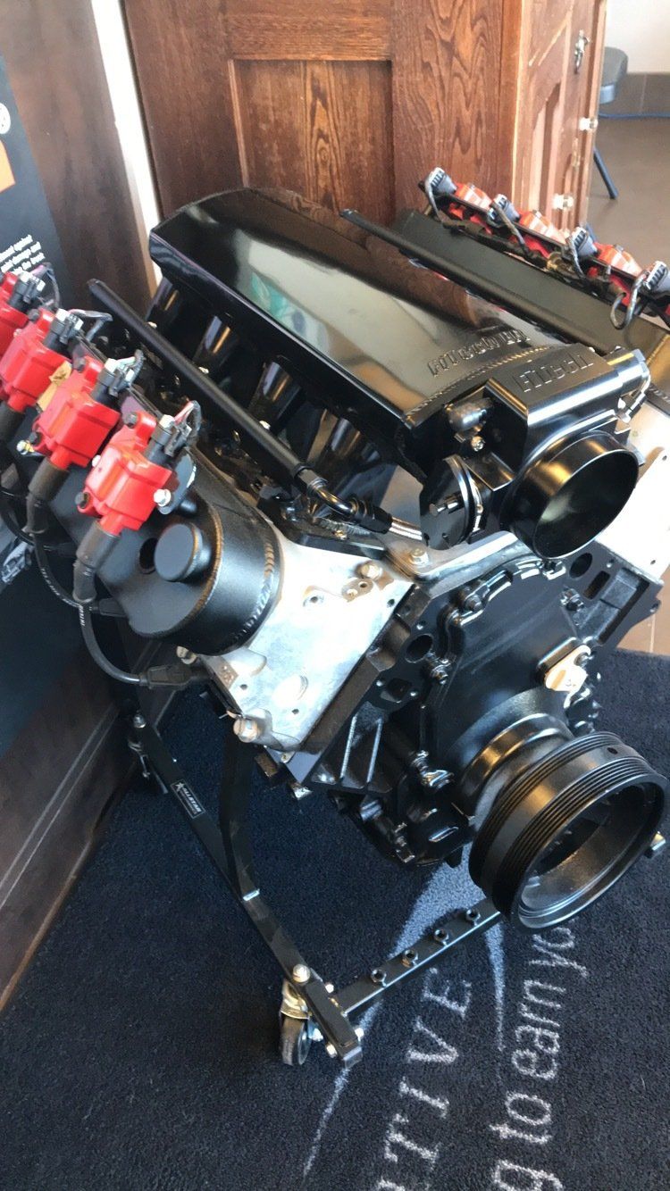 A black engine is sitting on top of a black mat.