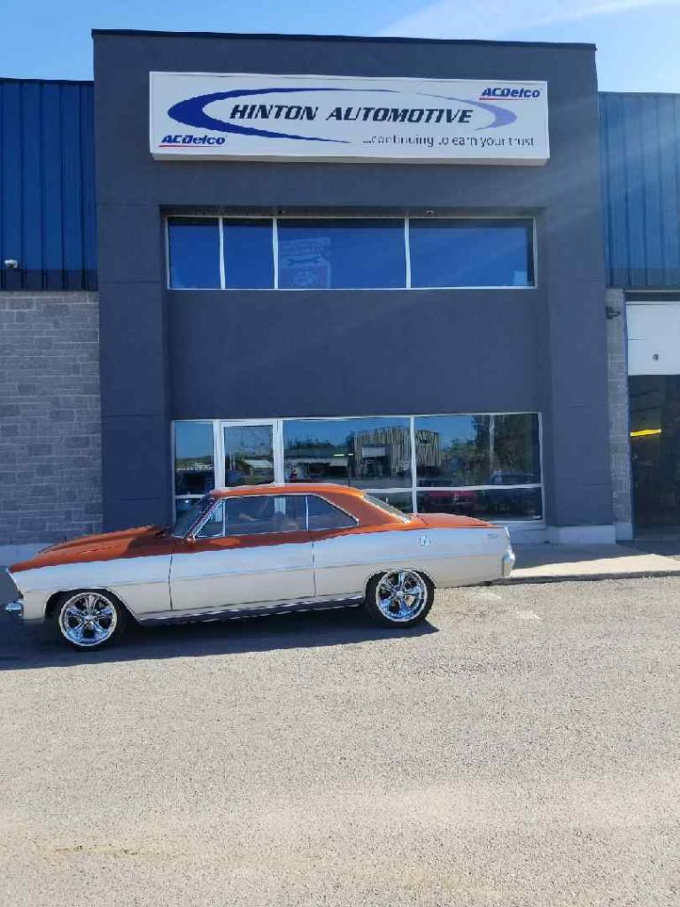 A white car is parked in front of a building.