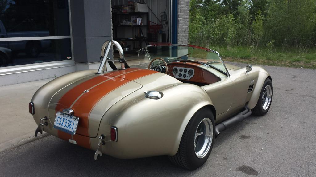 A silver and brown sports car with a license plate that says 15 tpb