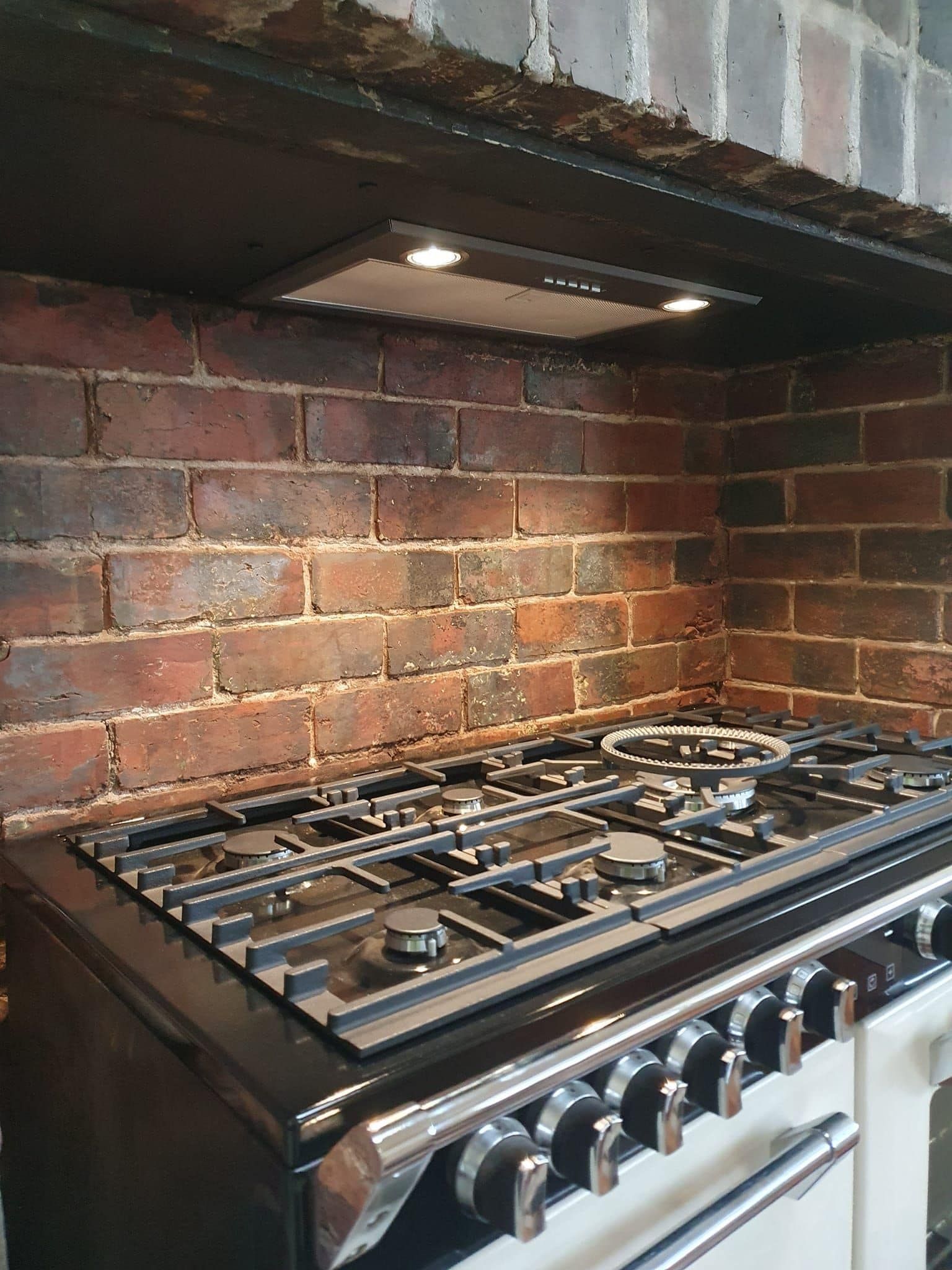 Brick Backsplash Above a Stove, Lit by a Small Overhead Light — Atack Electrical in Brown Hill, VIC