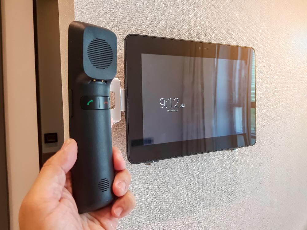 A Person Is Holding a Phone in Front of A Tablet — MNC Security In Bonville, NSW