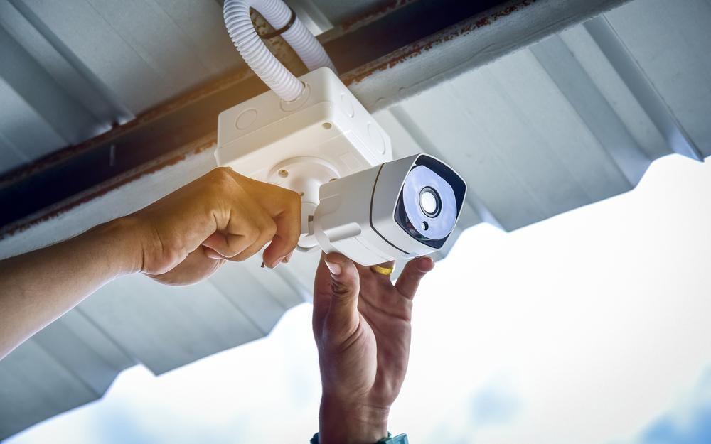 A Person Is Installing a Security Camera — MNC Security in Woolgoolga, NSW