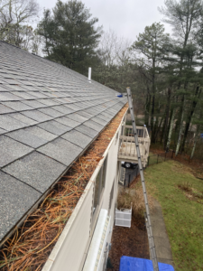 A gutter on the side of a house with a ladder attached to it.