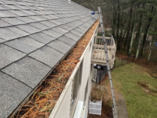 A gutter on the side of a house with a ladder attached to it.