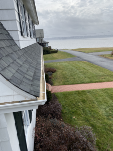 A white house with a gutter on the side of it