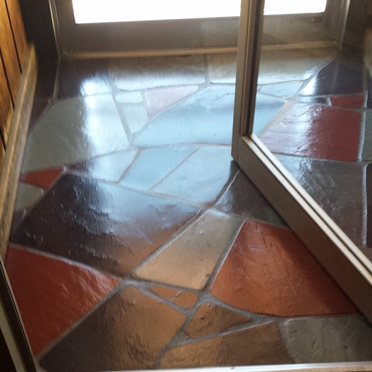 A tiled floor with a door in the background