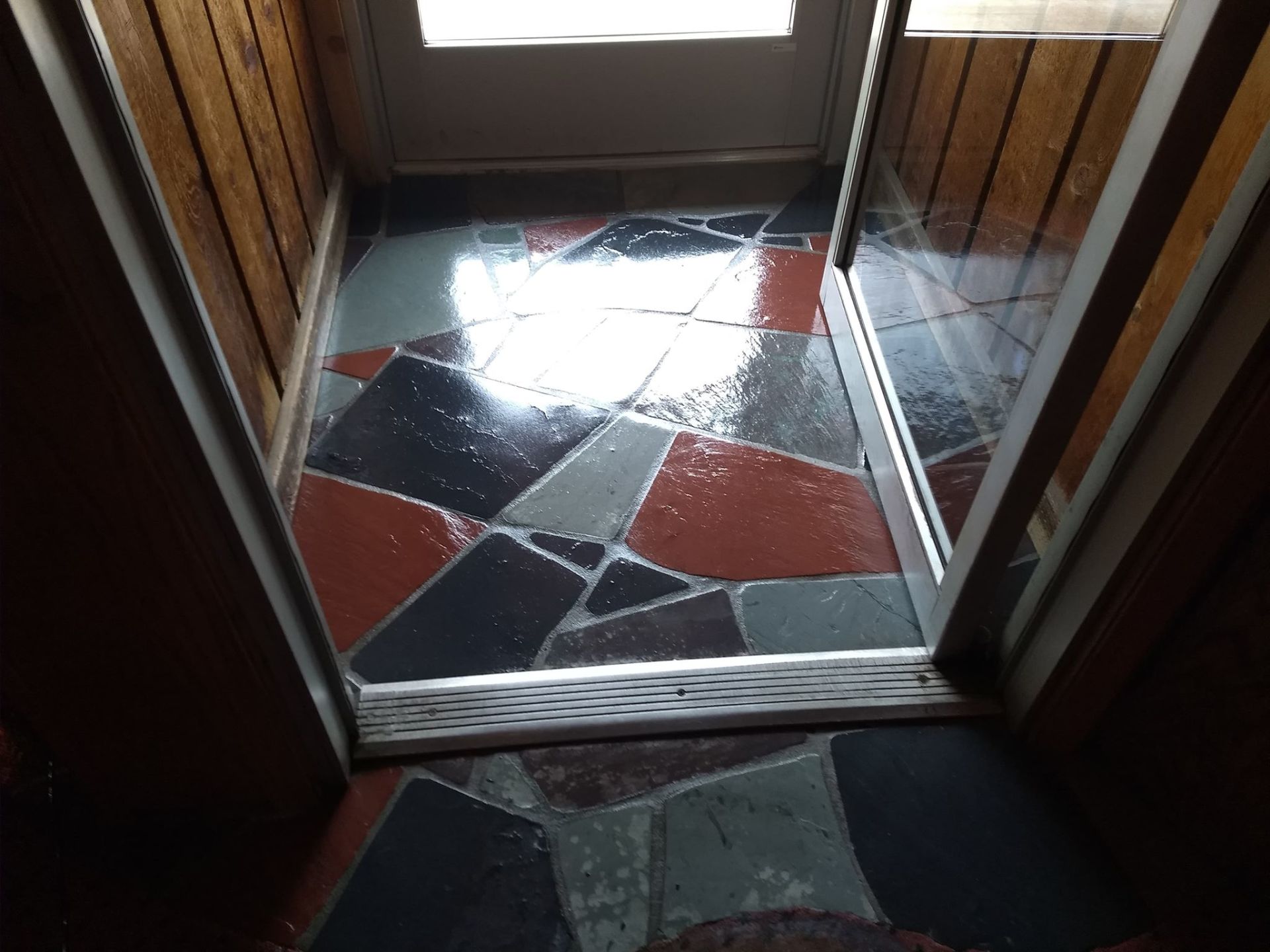A doorway with a tiled floor and a wooden wall