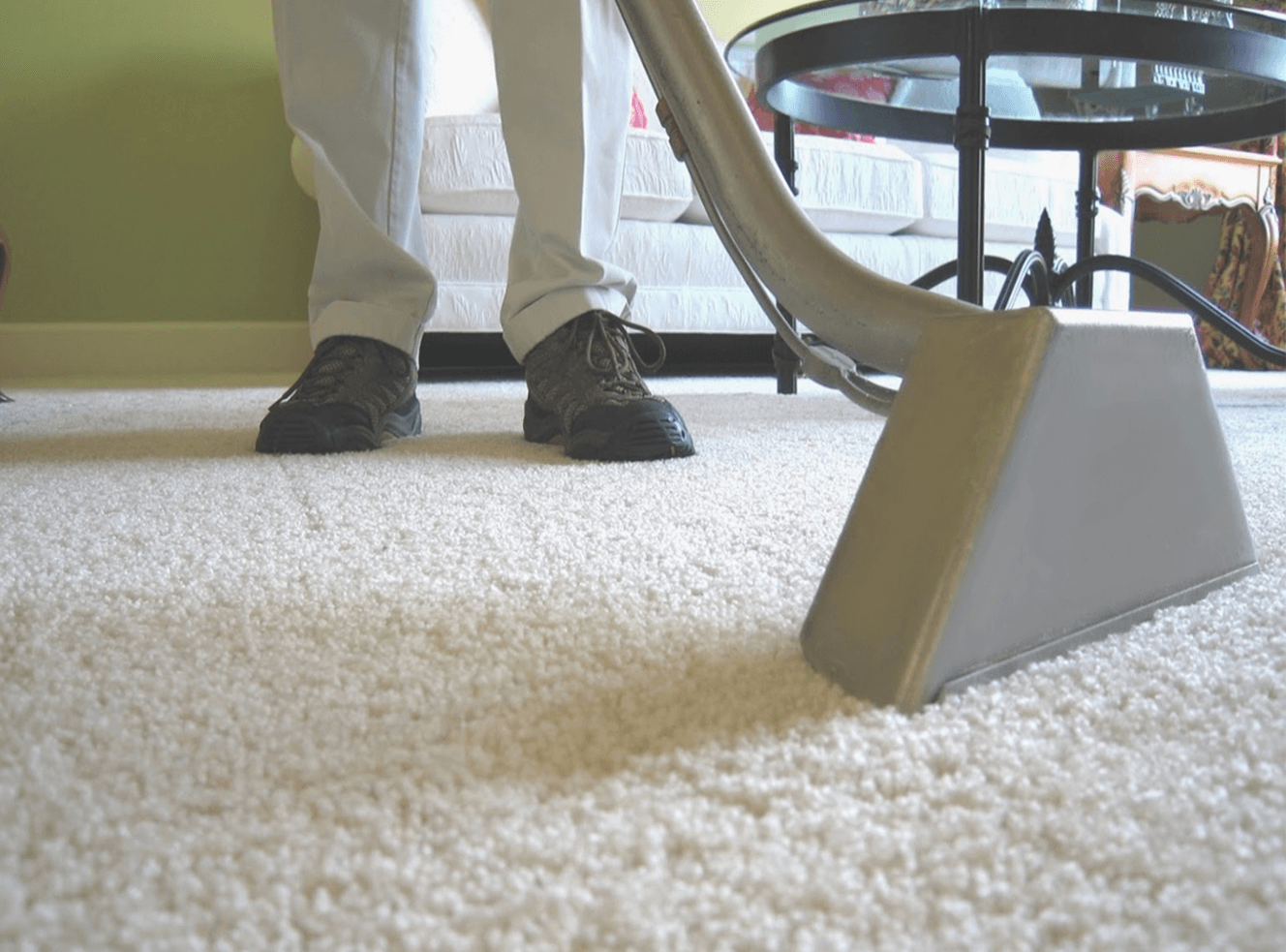 A person standing on a white carpet next to a table