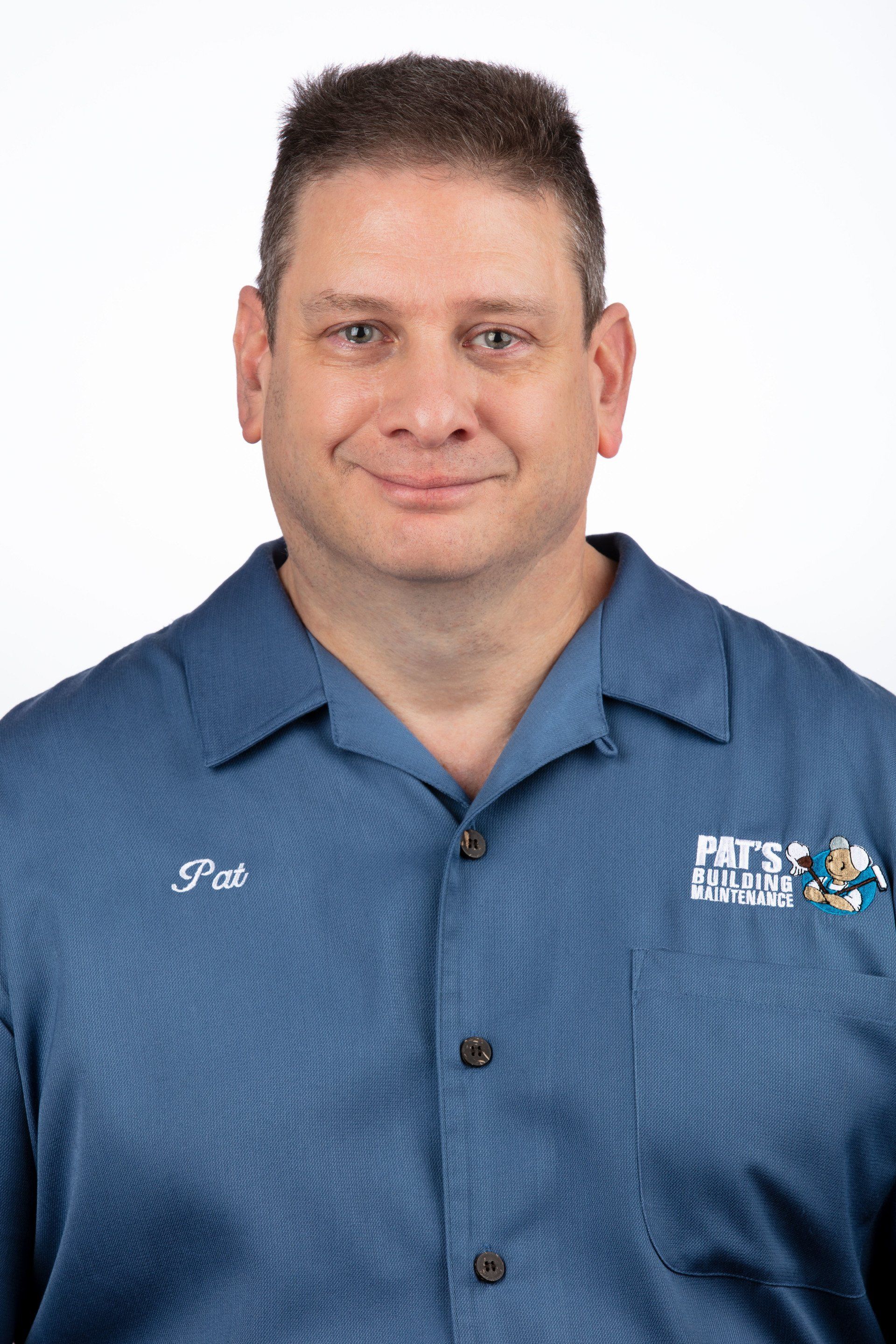 A man in a blue shirt is smiling for the camera.