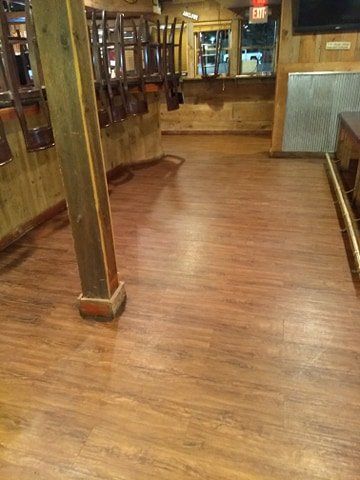 A restaurant with wooden floors and tables.