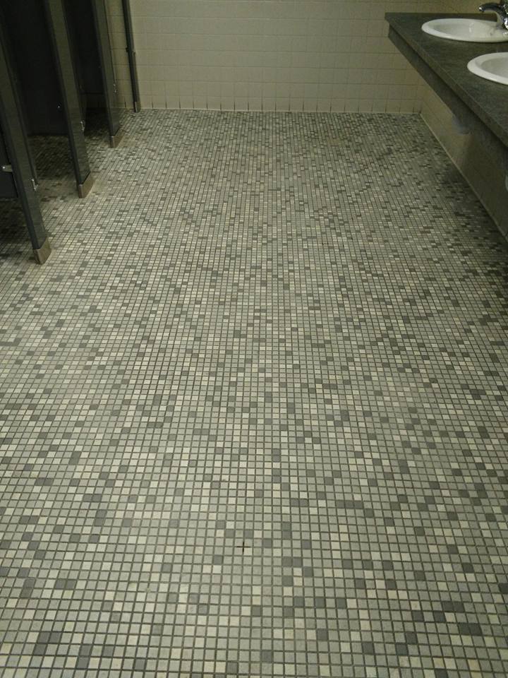 A bathroom with a tiled floor and two sinks.