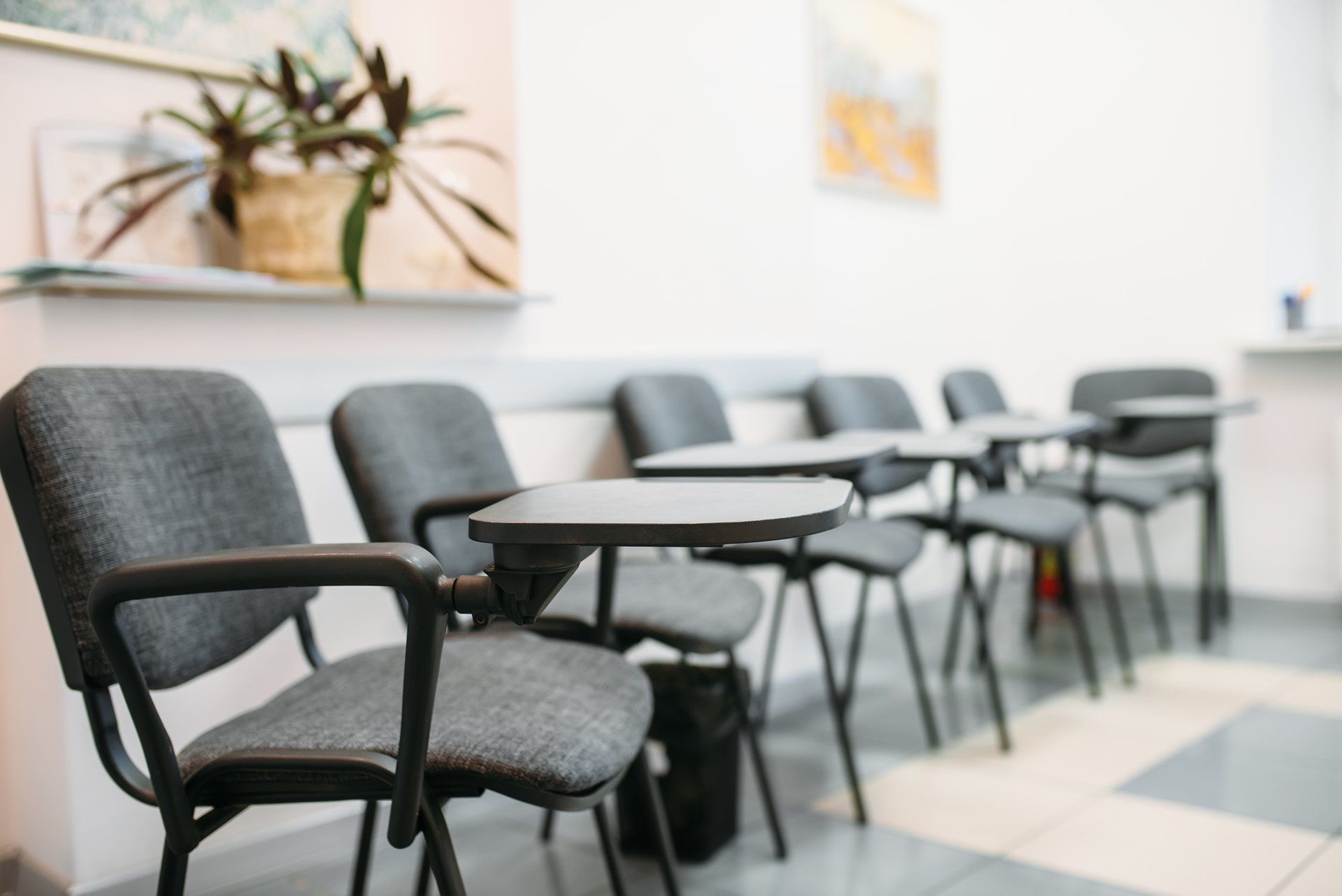 A row of chairs and tables in a waiting room.