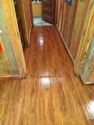 A hallway with a wooden floor and a wooden wall.