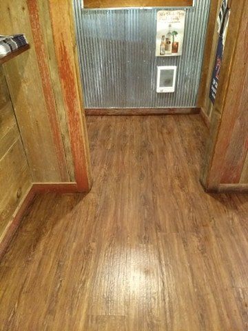 A room with a wooden floor and a metal wall.