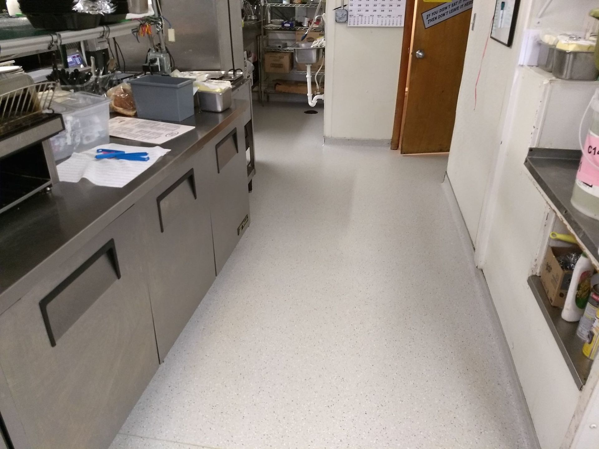 A kitchen with a white floor and stainless steel cabinets