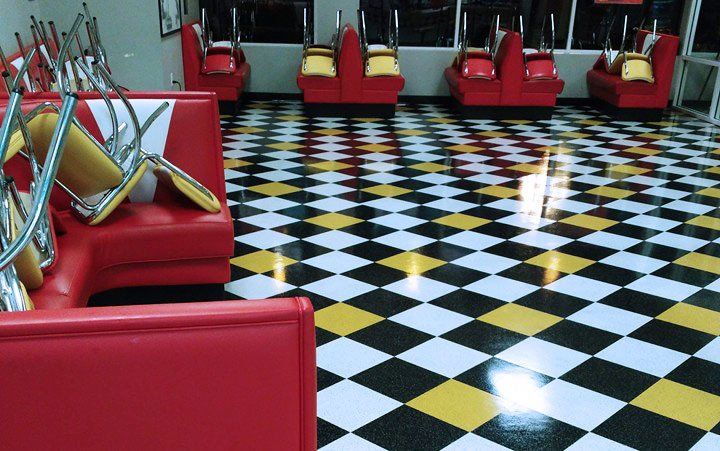 A diner with a checkered floor and red chairs
