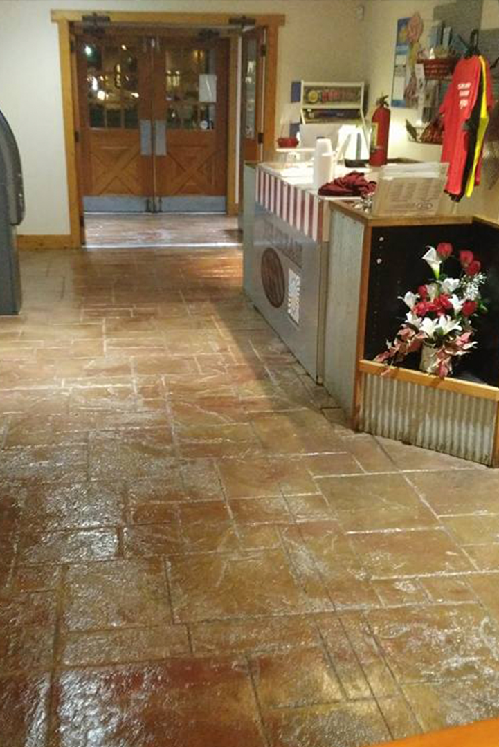 A room with a tiled floor and a fire extinguisher on the wall