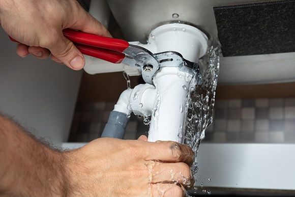 Plumber Fixing Sink Pipe with Adjustable Wrench — Sanford, FL — Hancock Plumbing Co Inc