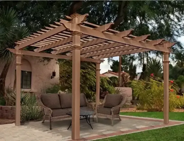 A wooden pergola stands on a paved patio in a landscaped backyard, featuring cushioned outdoor seating underneath.